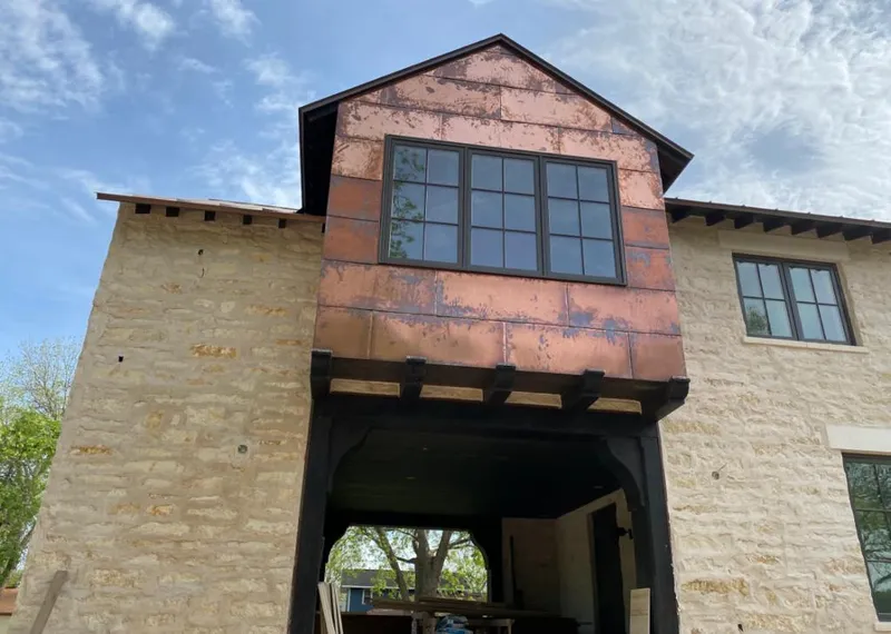Copper metal panel facade on a stone building for Skylight Installation in Whitefish Bay